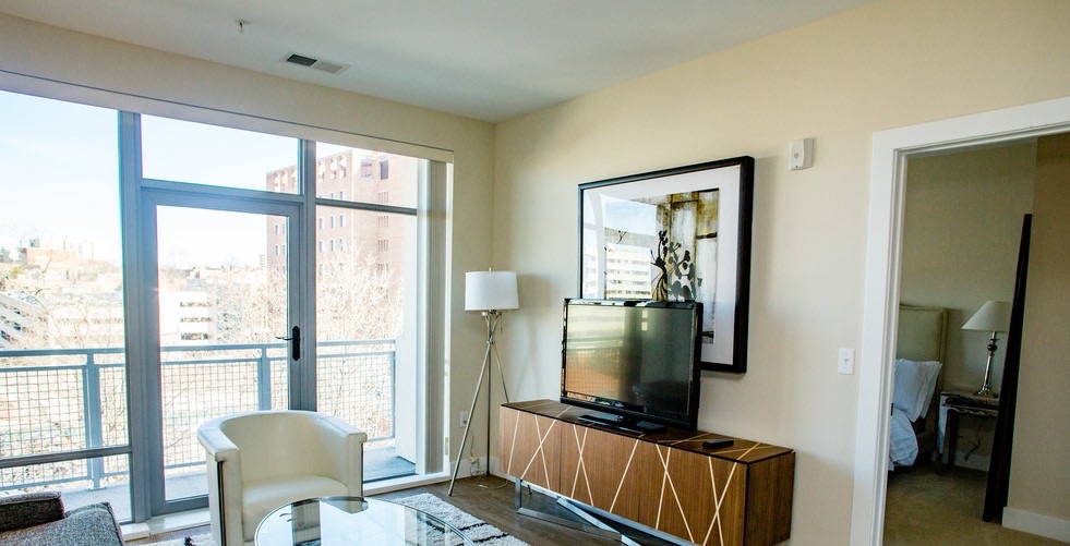 A Bedford Hall living room opening onto a private balcony with neighborhood views